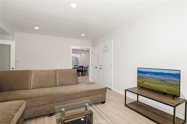 living area with baseboards, light wood finished floors, and recessed lighting