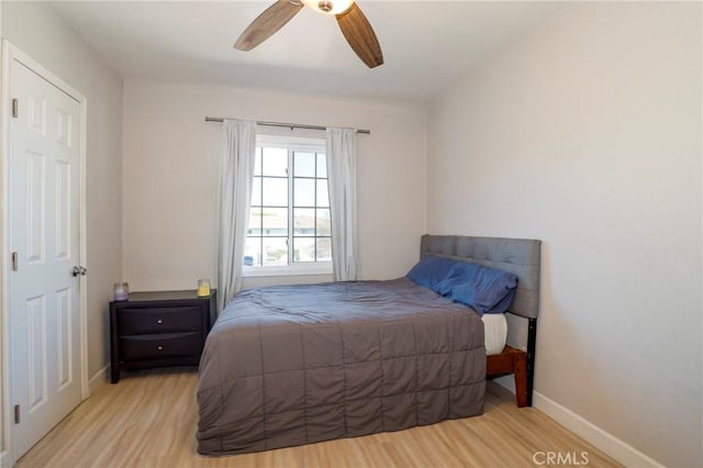 bedroom featuring light wood-type flooring, ceiling fan, and baseboards