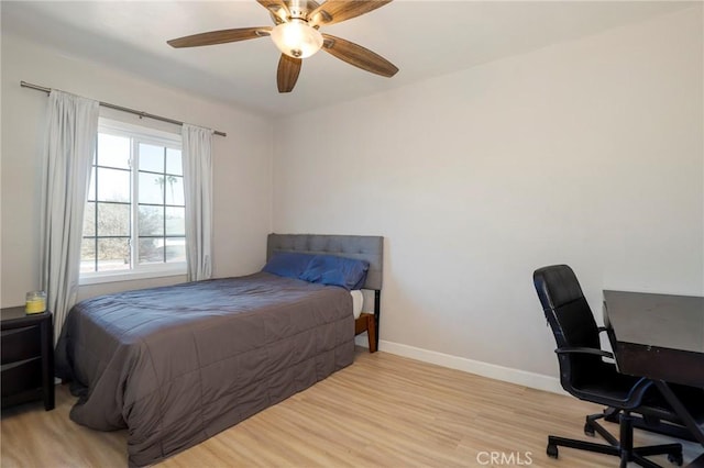 bedroom with light wood finished floors, ceiling fan, and baseboards