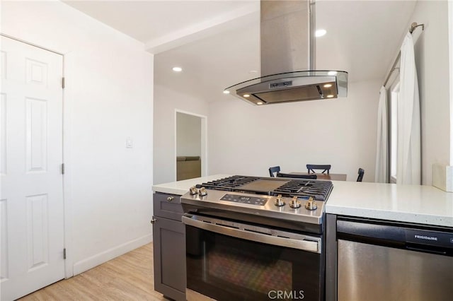 kitchen featuring light countertops, appliances with stainless steel finishes, island exhaust hood, and light wood-style flooring