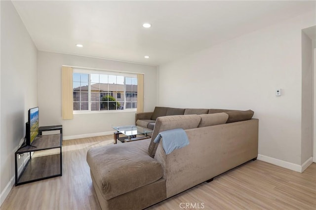 living area with light wood-type flooring, baseboards, and recessed lighting