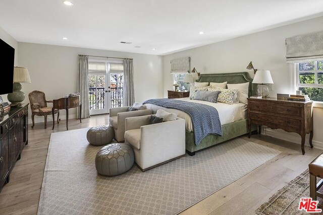 bedroom with french doors, light hardwood / wood-style flooring, and access to outside