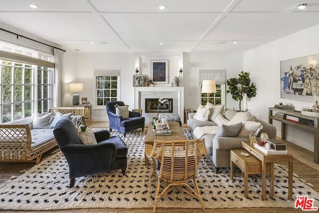 living room with wood-type flooring and coffered ceiling