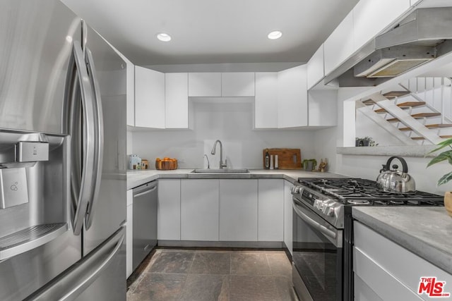 kitchen with ventilation hood, appliances with stainless steel finishes, sink, and white cabinets