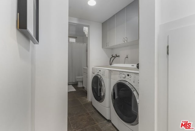 laundry area with washing machine and dryer and cabinets