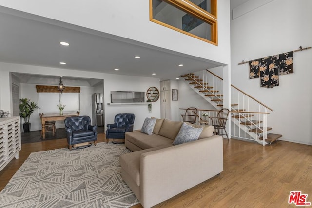 living room featuring hardwood / wood-style flooring and a high ceiling