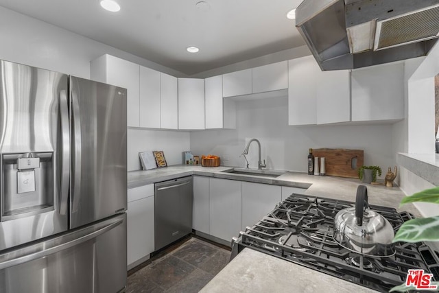 kitchen with white cabinetry, appliances with stainless steel finishes, range hood, and sink