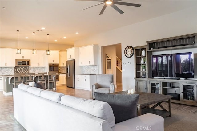 living room with ceiling fan and light hardwood / wood-style floors