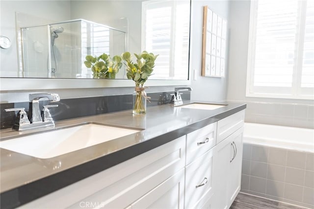 bathroom featuring vanity, hardwood / wood-style flooring, and plus walk in shower