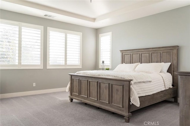 bedroom featuring a tray ceiling and light colored carpet