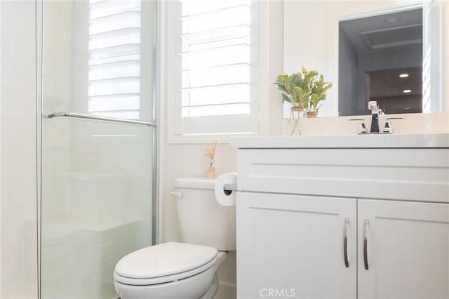 bathroom featuring a shower with shower door, sink, and toilet