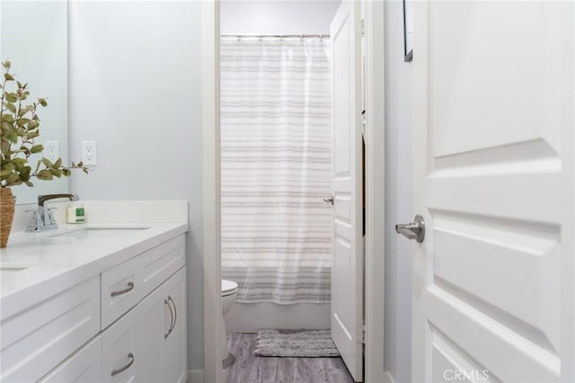 full bathroom with shower / bath combo with shower curtain, vanity, toilet, and wood-type flooring