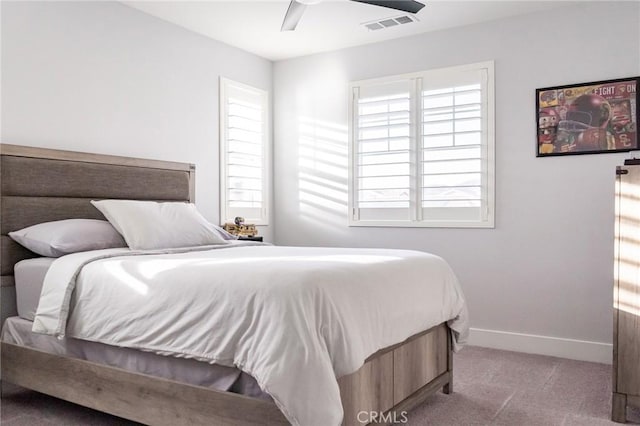 bedroom featuring multiple windows, light colored carpet, and ceiling fan