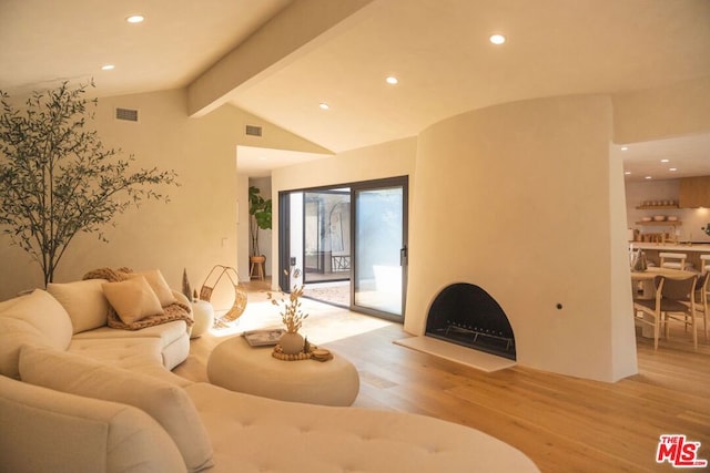 living room with vaulted ceiling with beams and light hardwood / wood-style floors