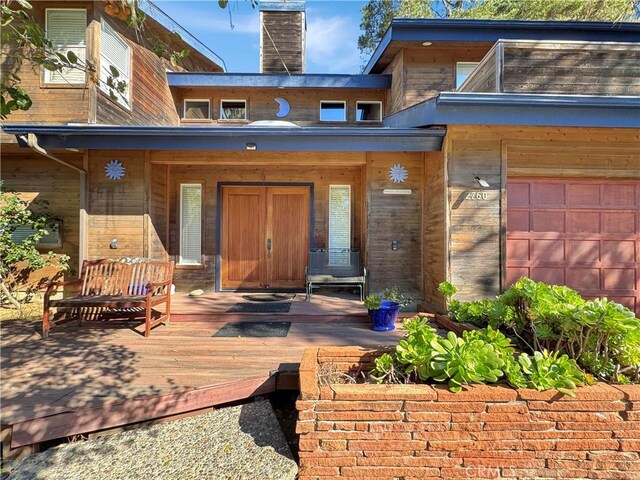 entrance to property featuring a garage and covered porch