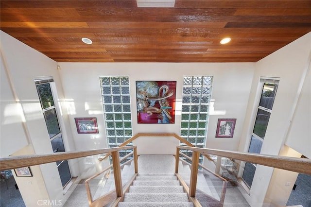 stairway featuring lofted ceiling, wooden ceiling, and recessed lighting