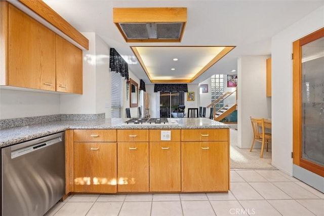 kitchen featuring gas stovetop, light tile patterned flooring, light stone countertops, dishwasher, and a peninsula