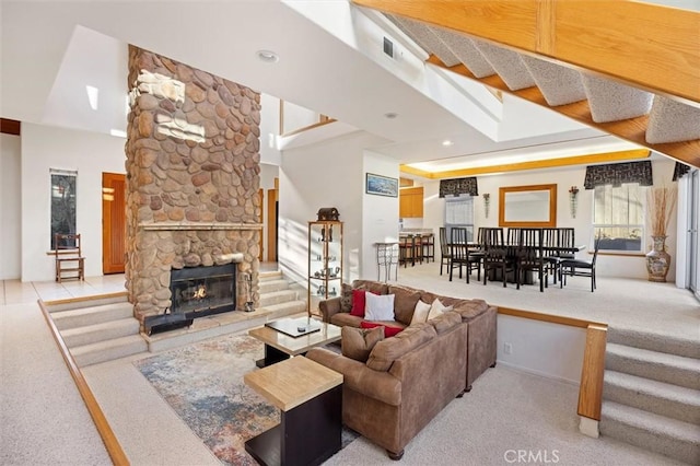 living area featuring stairs, a fireplace, and light colored carpet