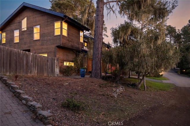 property exterior at dusk featuring fence