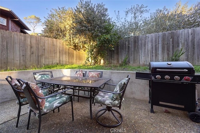 view of patio featuring outdoor dining area, grilling area, and a fenced backyard