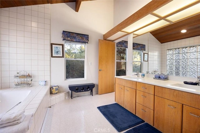 bathroom featuring lofted ceiling with beams, a sink, and tile walls