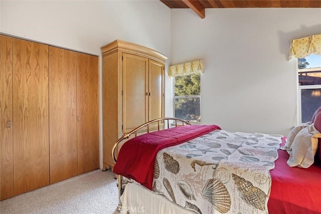 bedroom featuring carpet, multiple windows, and lofted ceiling with beams