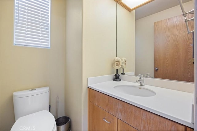 half bathroom with vanity and toilet