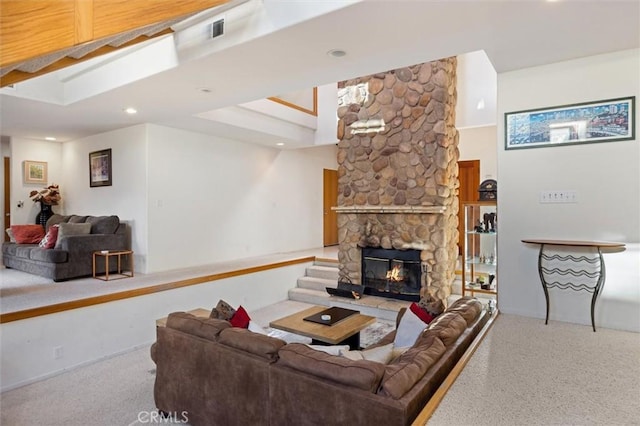 living area featuring a stone fireplace and recessed lighting