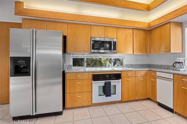 kitchen with appliances with stainless steel finishes and light tile patterned flooring