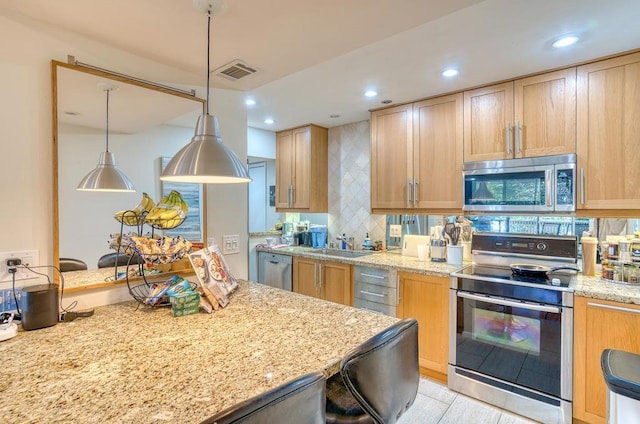 kitchen with light stone counters, stainless steel appliances, hanging light fixtures, and backsplash