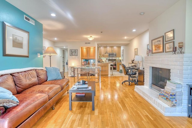 living room featuring light hardwood / wood-style flooring and a fireplace