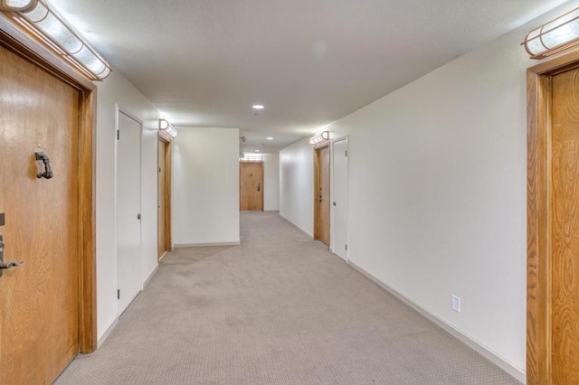 hallway featuring light colored carpet