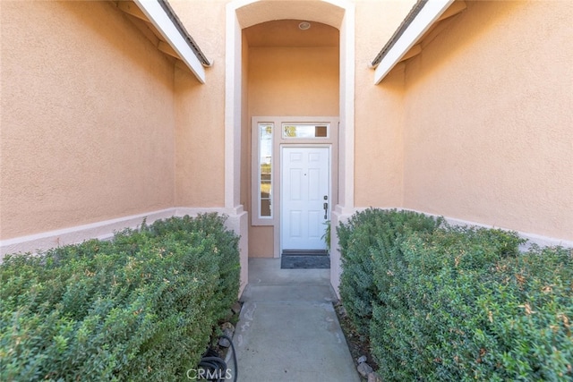 entrance to property featuring stucco siding