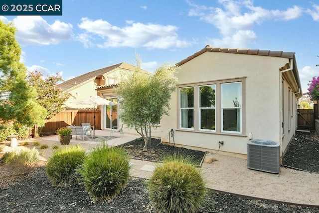 rear view of property featuring a patio area and central air condition unit