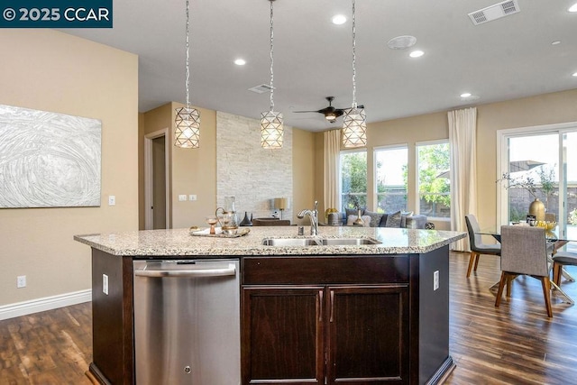 kitchen featuring sink, hanging light fixtures, stainless steel dishwasher, dark brown cabinets, and a center island with sink