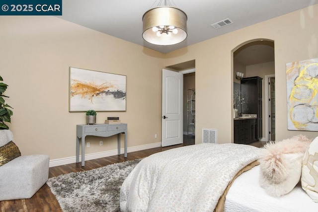 bedroom featuring dark hardwood / wood-style flooring and ensuite bath