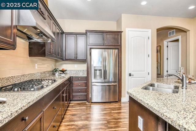 kitchen featuring light stone counters, appliances with stainless steel finishes, sink, and dark brown cabinets