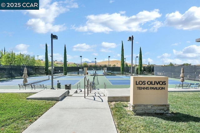 view of tennis court with a yard