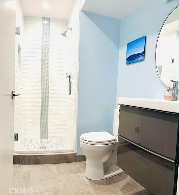 bathroom featuring vanity, an enclosed shower, and toilet