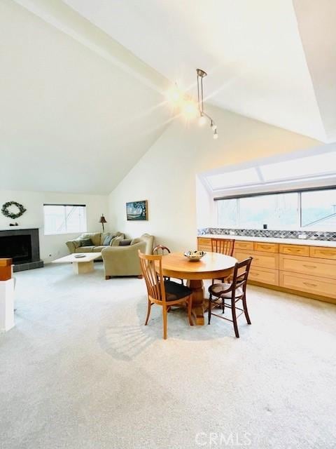 carpeted dining room featuring lofted ceiling with beams