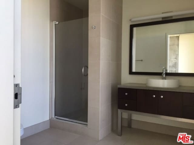 bathroom featuring vanity, toilet, an enclosed shower, and tile patterned flooring