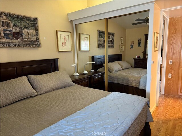 bedroom featuring vaulted ceiling, ceiling fan, light hardwood / wood-style floors, and a closet