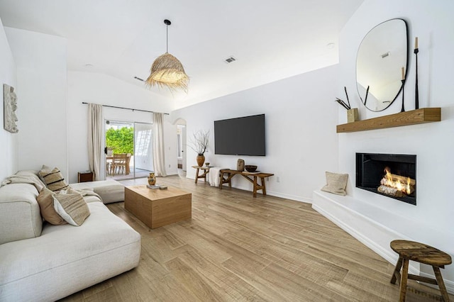 living room featuring lofted ceiling and light hardwood / wood-style flooring