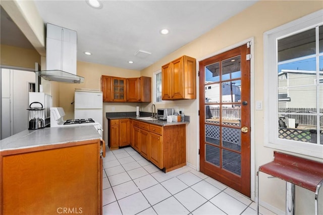 kitchen with sink, island range hood, light tile patterned floors, and white fridge