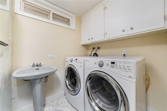 laundry room with cabinets, washer and dryer, and sink