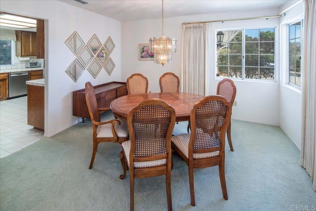 carpeted dining room featuring a notable chandelier