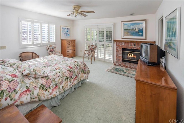 carpeted bedroom with a fireplace and ceiling fan