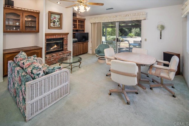 carpeted living room with a fireplace and ceiling fan