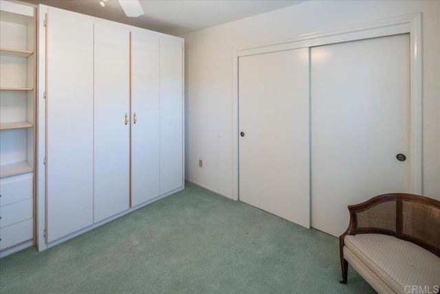 unfurnished bedroom featuring ceiling fan, light colored carpet, and a closet