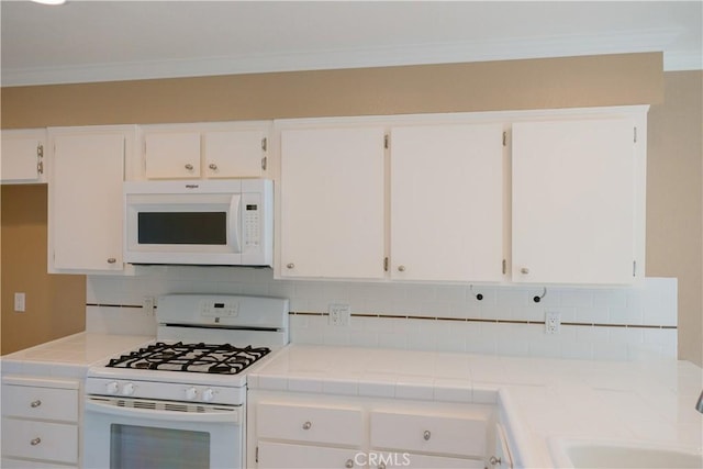 kitchen with white cabinetry, white appliances, crown molding, and tasteful backsplash